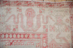 Expressive cloudband and blossom motifs in cherry red on a vintage distressed Oushak rug.