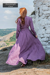 Woman wearing a purple heavyweight linen A-line maxi dress with tie waist outdoors