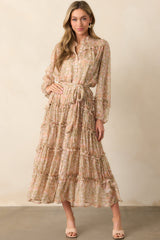 This blush maxi dress offers an elegant floral tulle overlay, a round neckline, functional button details, smocked shoulder panels, and long sleeves with elastic cuffs.