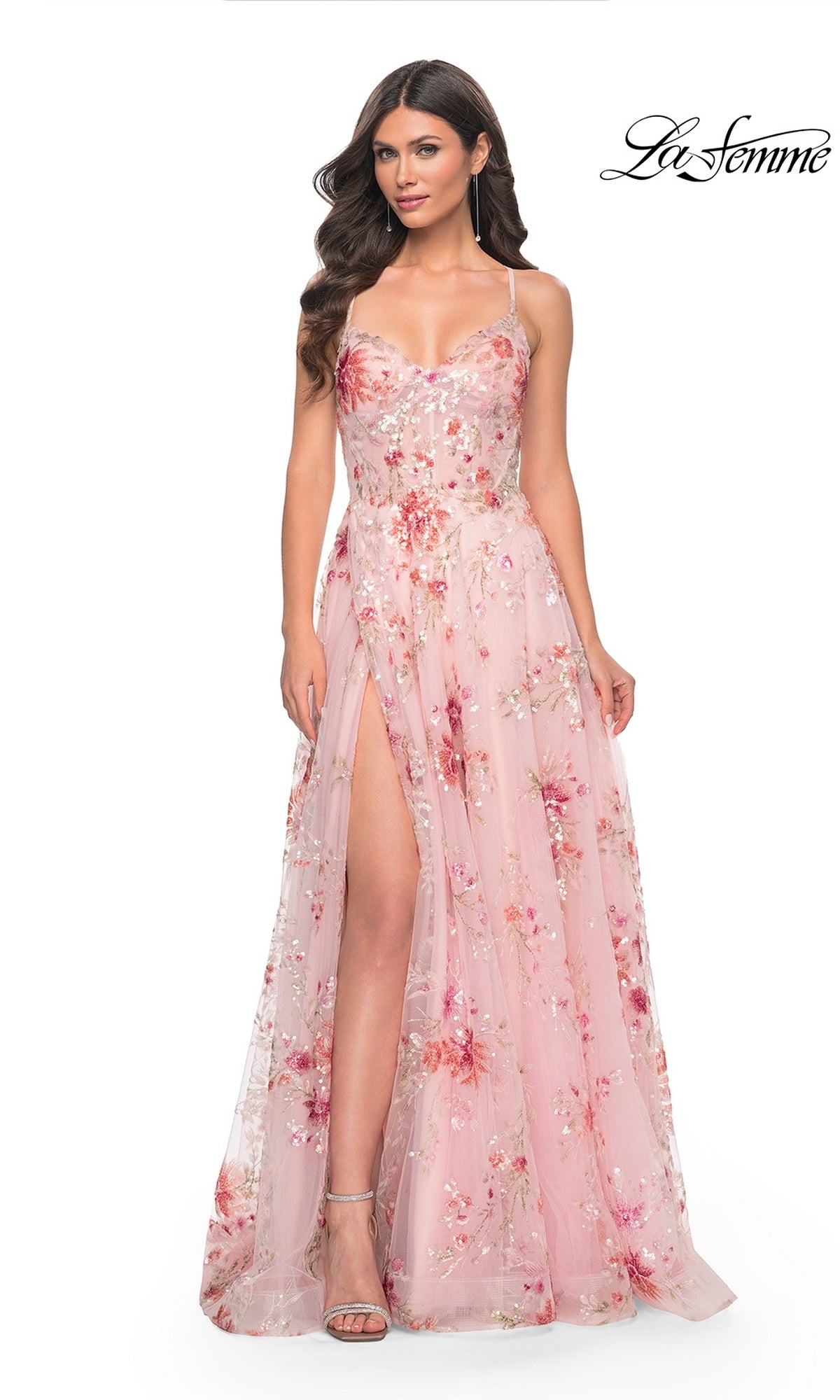 A woman wears the La Femme Floral-Sequin Long A-Line Prom Dress 32031, featuring pink floral sequins and a thigh-high slit, standing against a white background with the "La Femme" logo in the top right corner.
