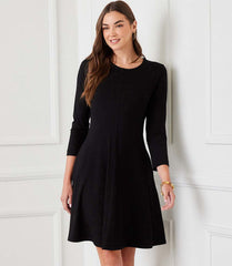 Woman wearing a 3/4 sleeve fit and flare dress in heavy rayon spandex jersey with scoop neck and side pockets
