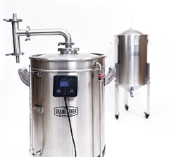 En Grainfather G40 & G70 Steam Condenser (Dampkondensator) fra Grainfather er i forgrunnen, festet til et bryggesystem i rustfritt stål med digitale kontroller; en konisk fermenter vises i bakgrunnen.