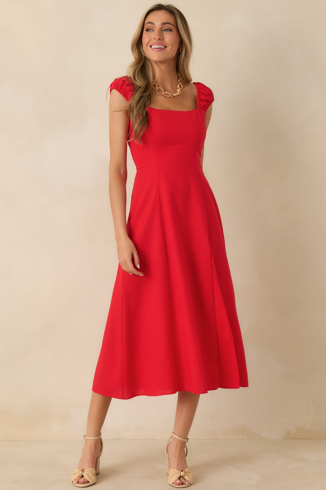 Angled front view highlighting the smocked sleeves and fluid drape of the skirt.