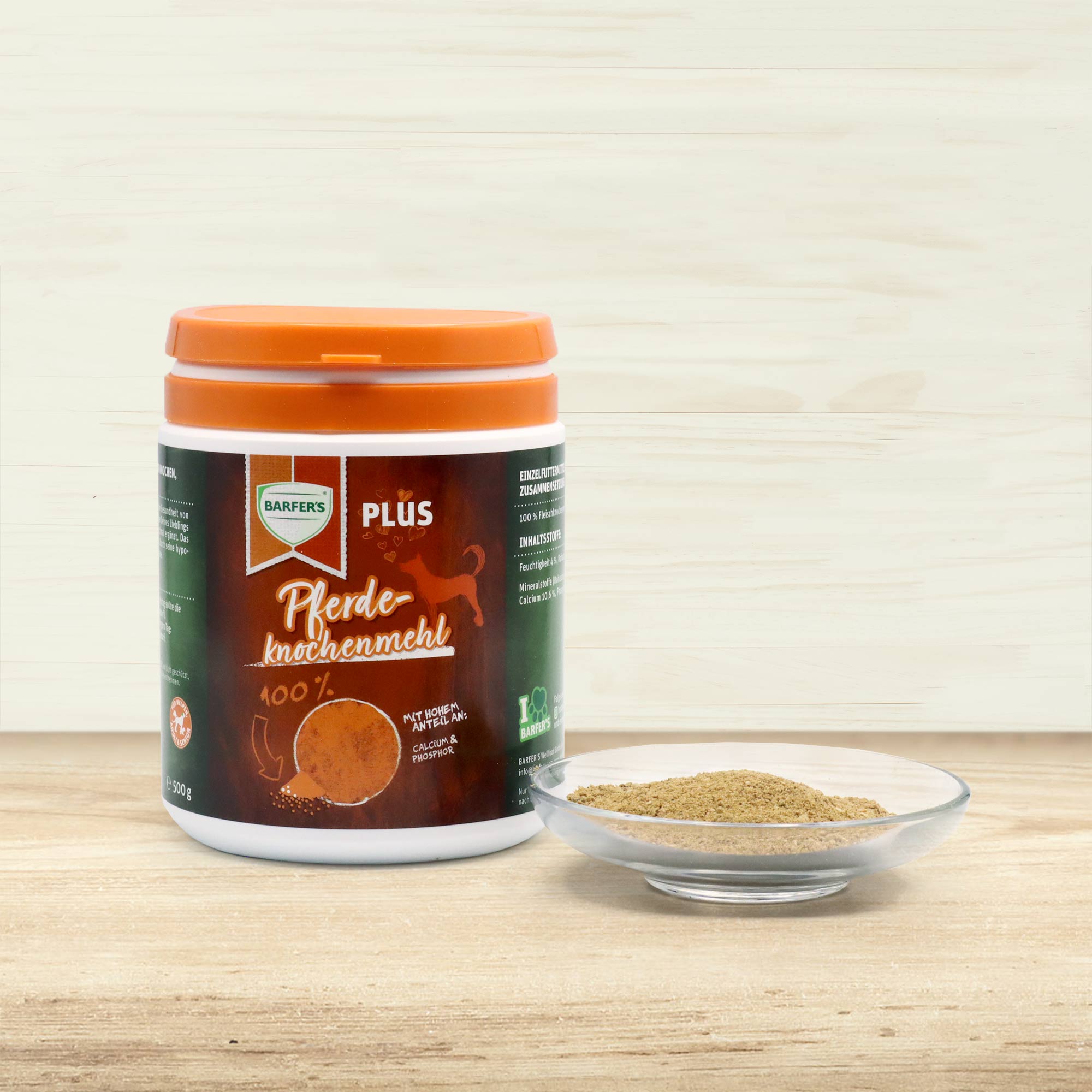 500 g Dose BARFER’S Pferdeknochenmehl mit orangefarbenem Deckel und braunem Etikett, daneben Glasschale mit Pferdeknochenmehl-Pulver, auf hellem Holzuntergrund vor hellen Holzwänden