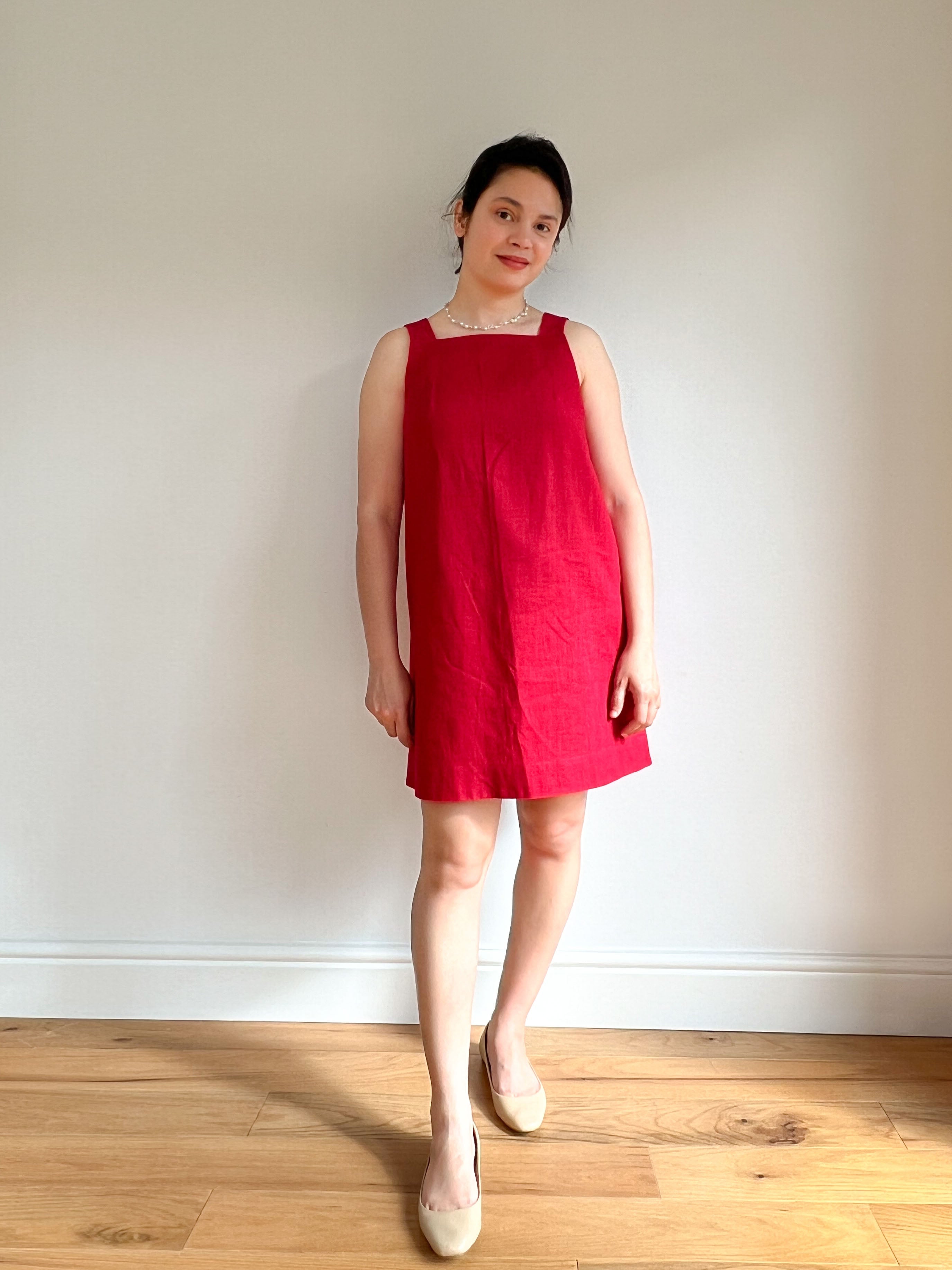Woman wearing the Sabrina Dress sewing pattern from Bella Loves Patterns on The Fold Line. A shift dress pattern made in linen, chambray, lightweight denim, or cotton fabric, featuring a relaxed fit, high square neckline in front, V-neckline in back, wide straps, and mini length.