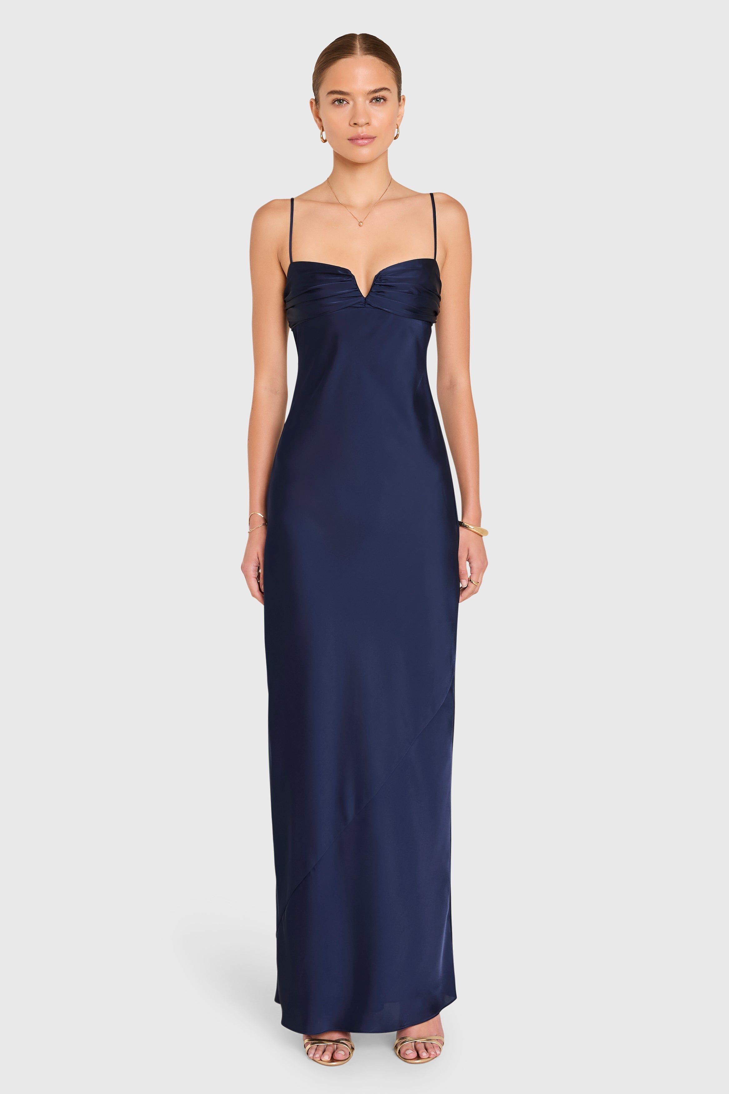 Woman wearing a navy blue evening gown on a white background