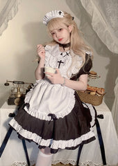 Person in a maid outfit sitting at a table with a vintage scale and basket.