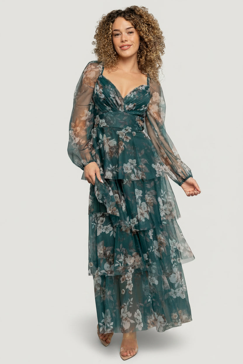 Front view of model wearing the Tessa Tiered Maxi Dress in green floral tulle with sweetheart V-neck and long sheer sleeves, full-length.