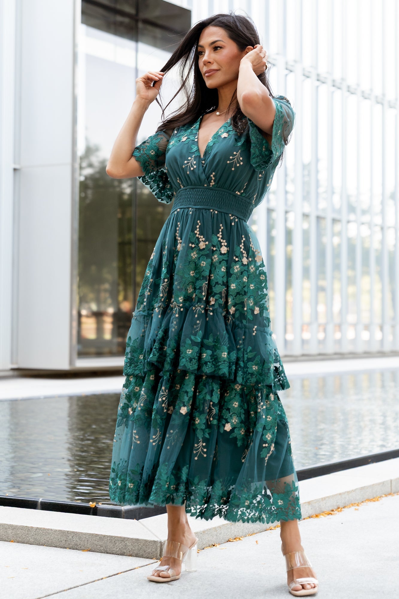 Front view of Lotte emerald midi dress showing deep teal tulle, crossover V-neck and layered gold and emerald floral embroidery across the bodice.