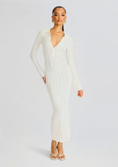 Full-length shot of a model wearing a white rib knit maxi dress with a deep V neckline and long sleeves.