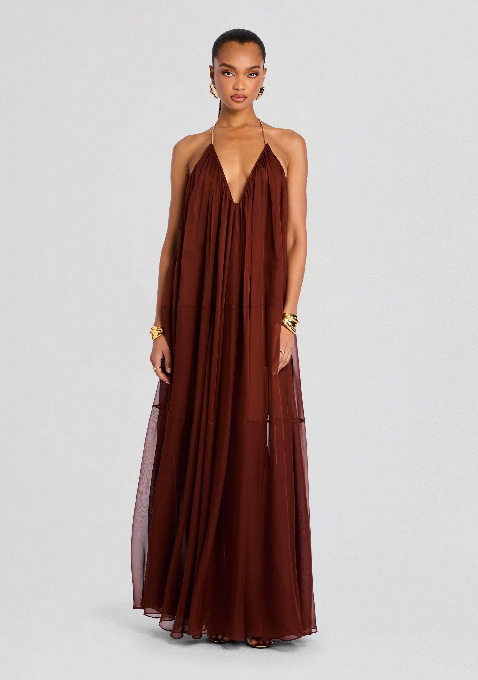 Brown chiffon halter maxi dress with deep V neckline and flowing layered skirt