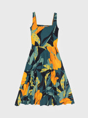 Lily Dress: Green organic cotton midi dress with bold orange and yellow tropical leaf print, square neckline.