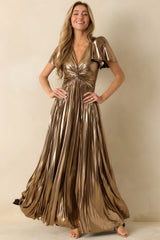 Flowing bronze metallic maxi dress with a twisted V-neck, flutter sleeves, and pleated A-line skirt with subtle foil-shine detailing.