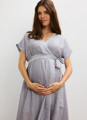 Light gray maternity dress with subtle dots, V-neck, short sleeves, and tied waist belt.