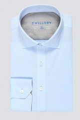 A neatly folded Leader Solid // Blue shirt by Twillory with a stiff collar, buttoned cuffs, and grey-lined inside collar. The Twillory brand is printed in blue. Displayed on a solid light grey background.
