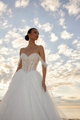 Sleeveless A-line wedding dress with pearl bodice, sweetheart neckline, glitter tulle skirt, off-the-shoulder pearl straps, and chapel train.