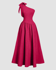 One-shoulder hot pink midi dress featuring a bow detail on the back and a fit-and-flare silhouette.