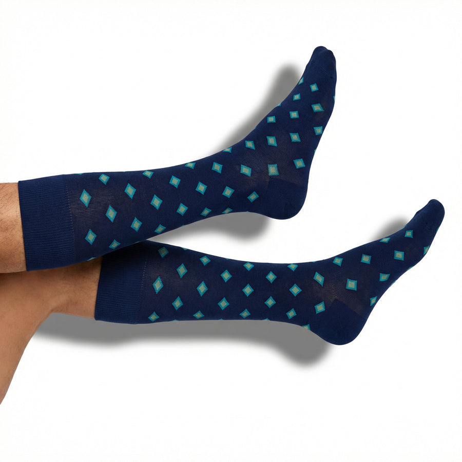 DeadSoxy Parker dress socks in navy with teal and gold diamond pattern worn on foot