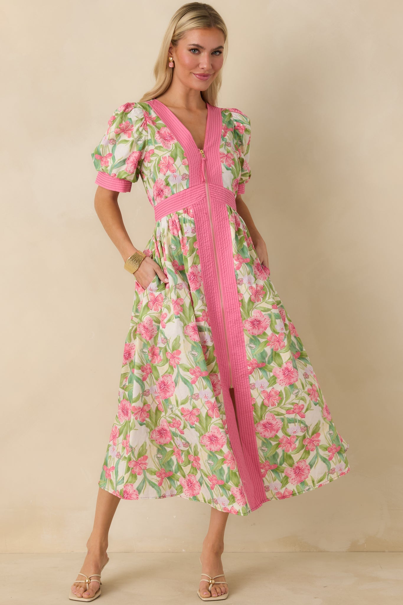 Front view of pink floral midi dress with V-neckline, short puff sleeves, and fitted waistband.