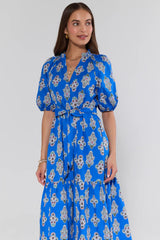 Woman wearing a blue floral dress against a white background