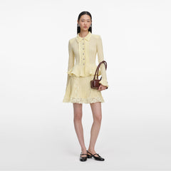 Front view of a woman wearing the Yellow Pointelle Peplum Knit Mini Dress