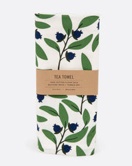 A tea towel with a blueberry pattern. Shown folded in its paper wrapping.