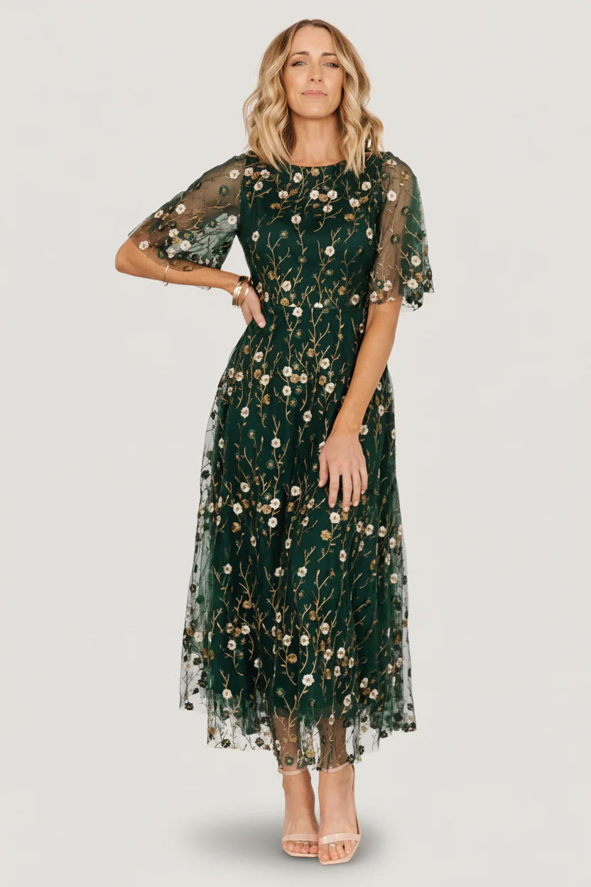 Front view of Arabella dark green embroidered tulle maxi dress with gold and ivory floral embroidery, round neckline, and layered skirt.