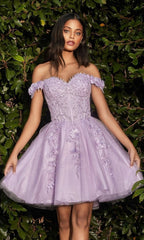 A woman wearing the Off-Shoulder Short Floral Homecoming Dress CD0194 stands before lush green foliage.