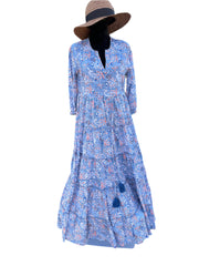 The dress in the image has a soft blue base color with orange, white, and navy blue paisley patterns. It also features blue tassel accents, adding a bohemian and elegant touch to the overall design.