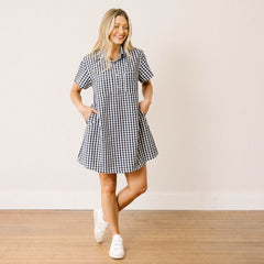 Woman wearing a black and white checkered dress against a plain background