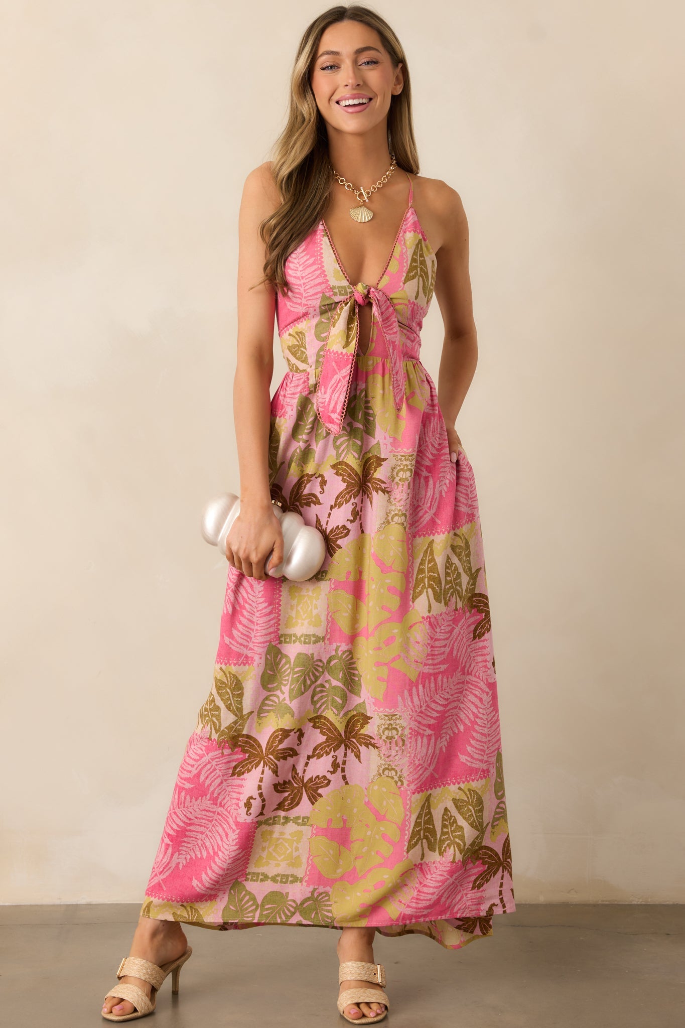 A pink dress with a deep v-neckline, self-tie front, and flattering cutout detail just below the bust.