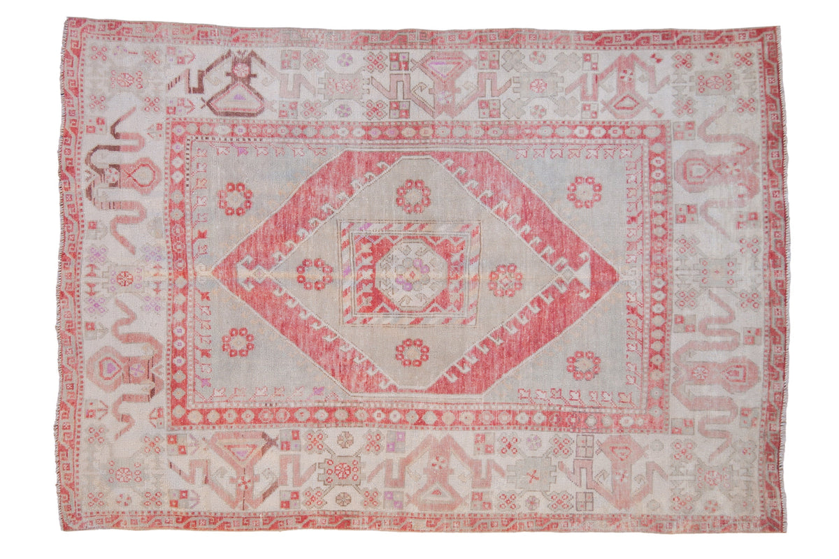 Vintage distressed Oushak carpet with a red diamond medallion on a faded silver-slate and ivory ground.