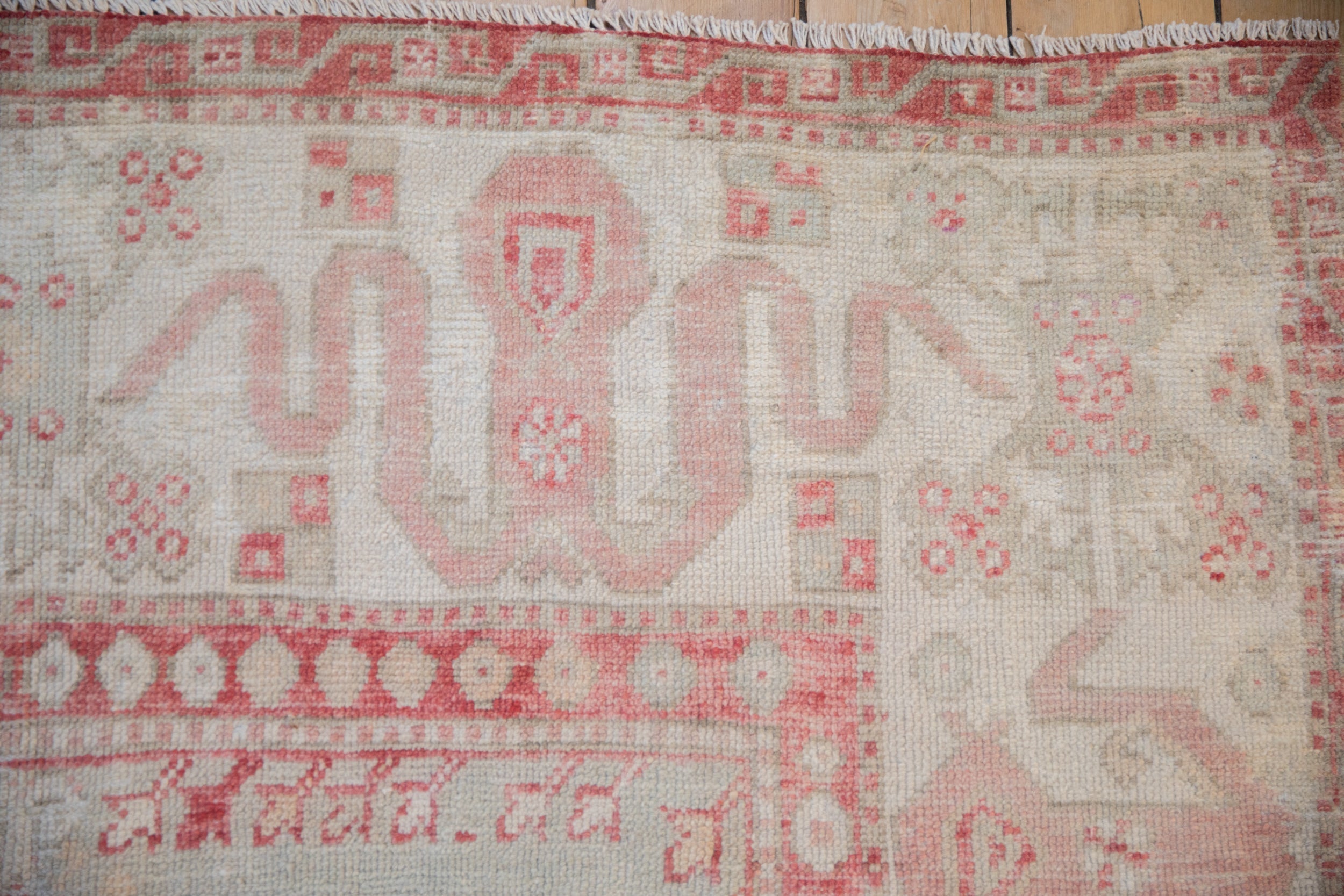 Expressive cloudband and blossom motifs in cherry red on a vintage distressed Oushak rug.