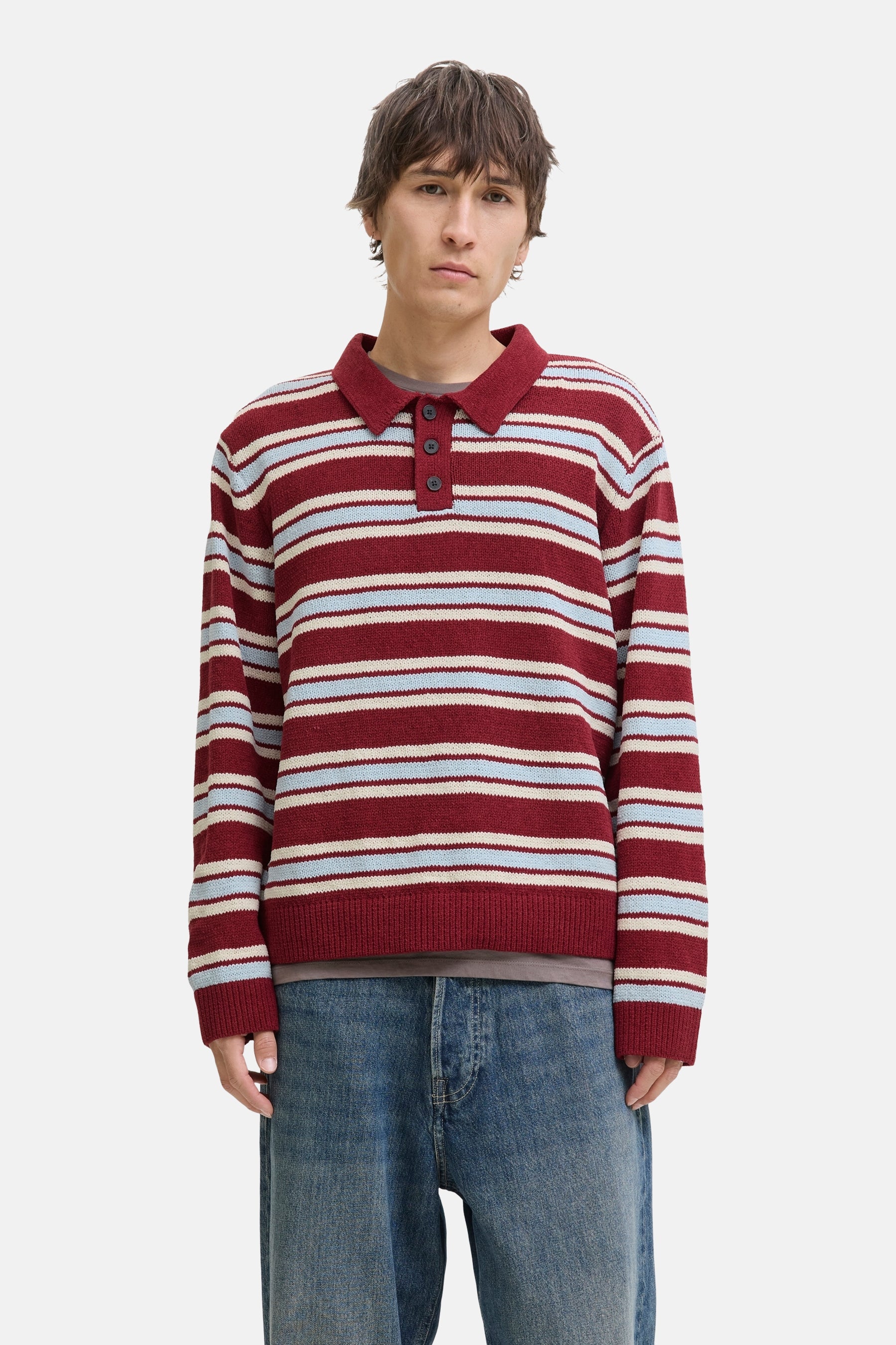 Rode trui met V-hals van ORIGINALS BY JACK & JONES, gestreept in rood, wit en blauw, gedragen met jeans.
