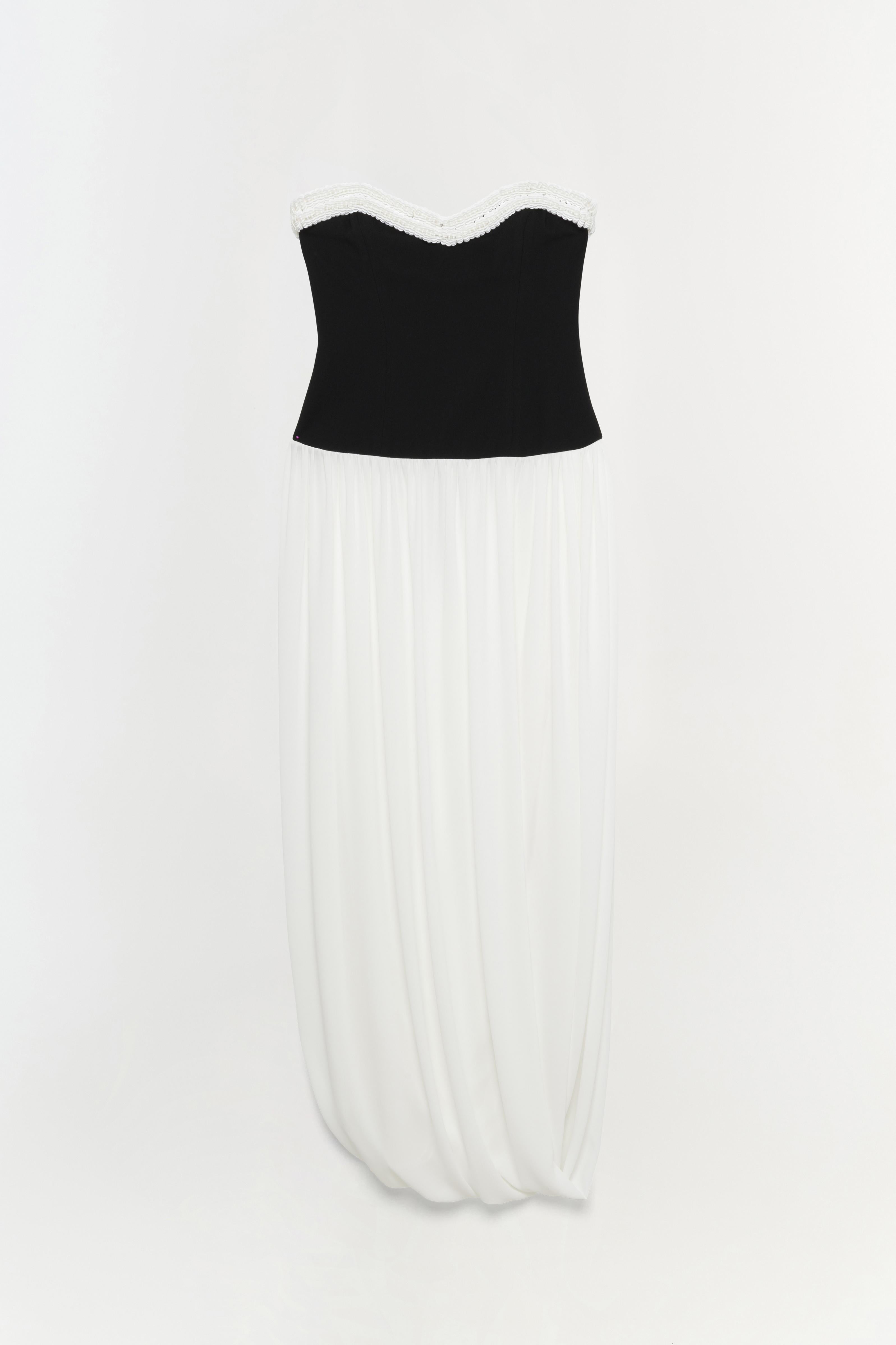 Strapless dress with black bustier top, white lace neckline trim, and ivory pleated skirt.