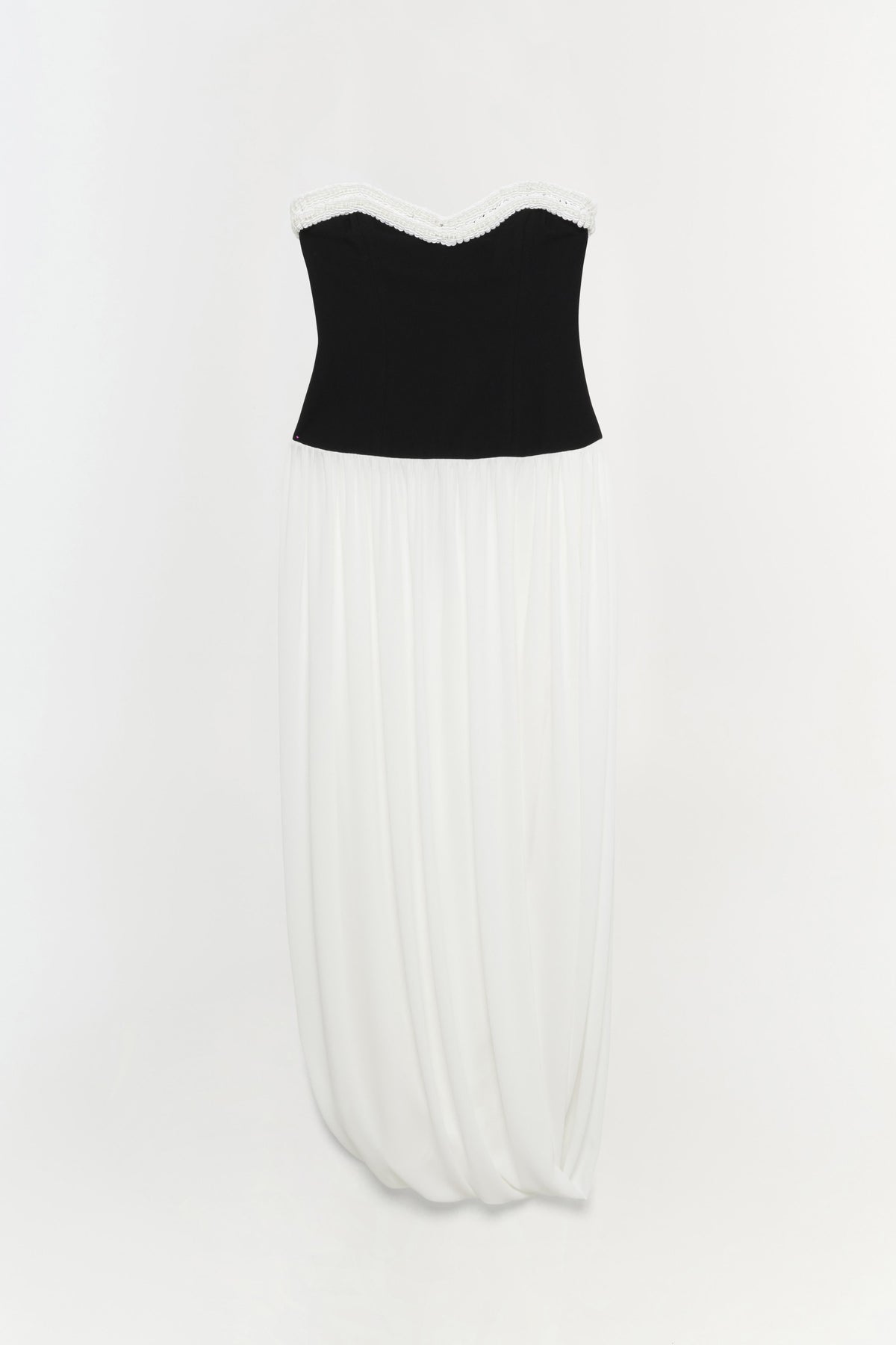 Strapless dress with black bustier top, white lace neckline trim, and ivory pleated skirt.