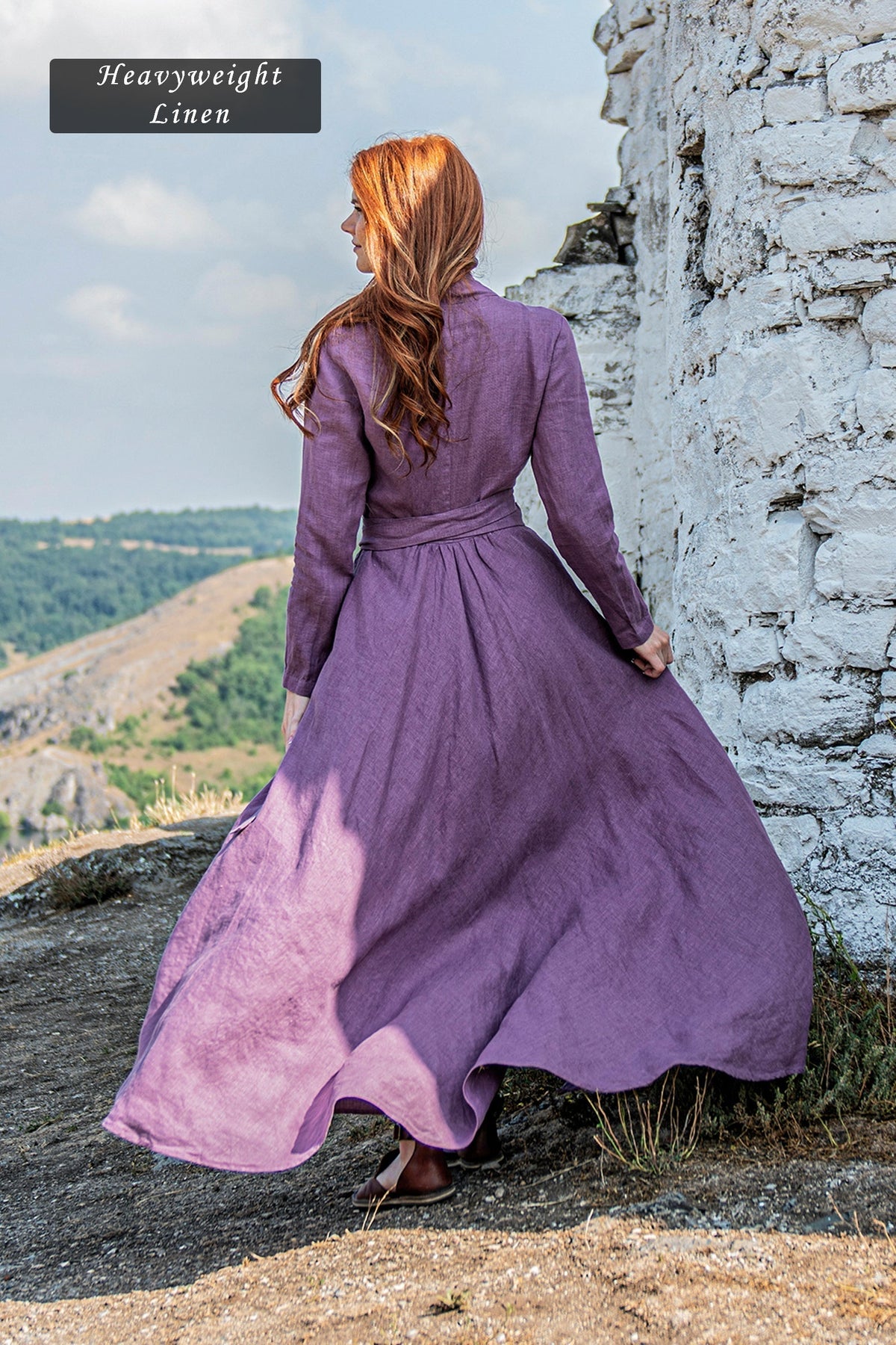 Woman wearing a purple heavyweight linen A-line maxi dress with tie waist outdoors