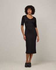 Model wearing London Fitted Dress in Black. London Fitted Dress is a merino wool short sleeve, v-neck, midi fitted dress available in sizes XS-3X Regular, XS-XL Petite.