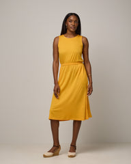 Model wearing Sofia Fit & Flare Dress in Mango, a sunshine yellow-orange color. Sofia Fit & Flare Dress is a merino wool sleeveless, crew neck, midi fit & flare dress with pockets available in sizes XS-XXL.