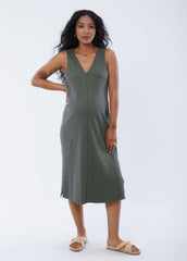 ||Pregnant woman wearing green v-neck sleeveless dress on a plain background