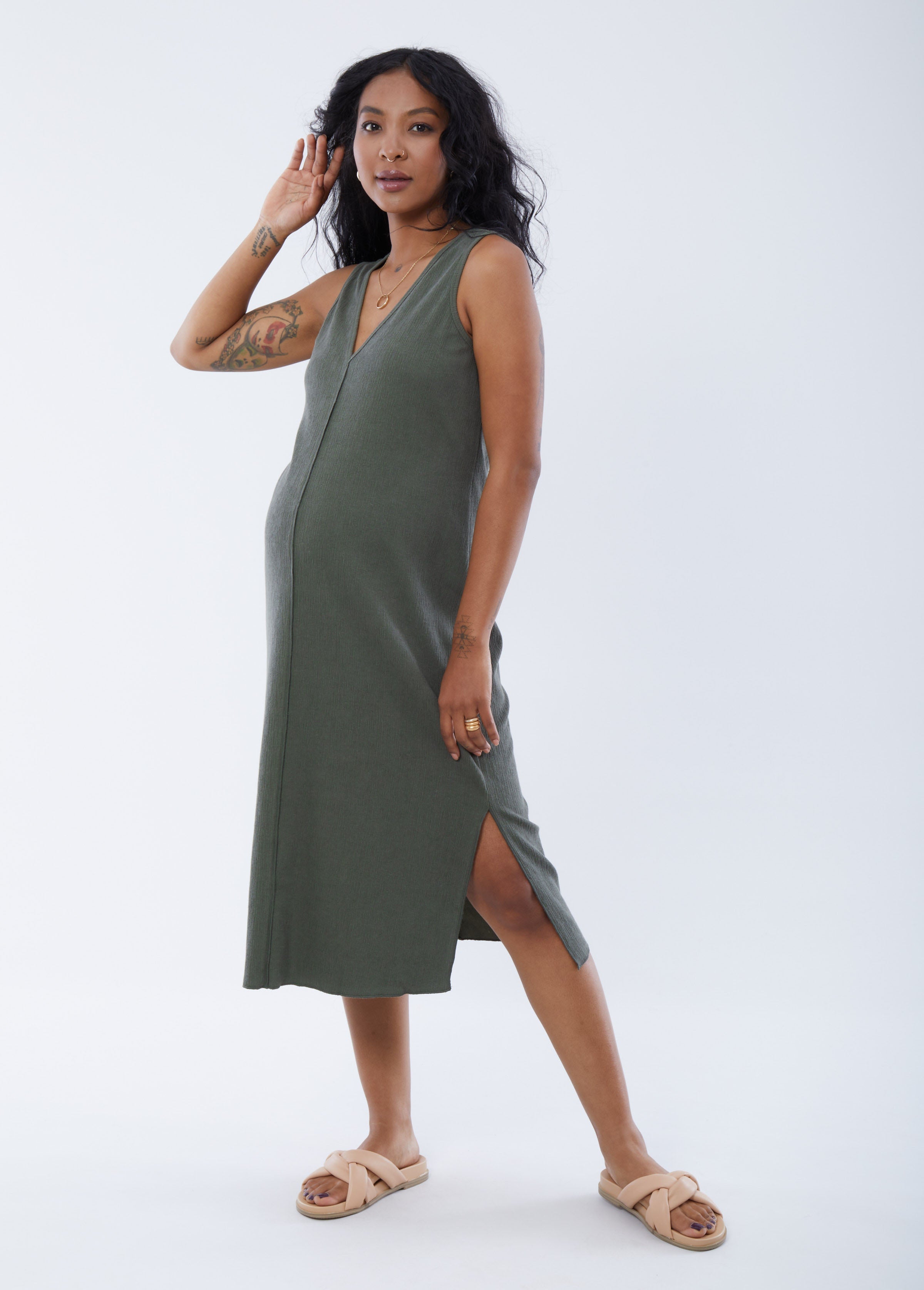 ||Olive::hover||Pregnant woman wearing green v-neck sleeveless dress on a plain background
