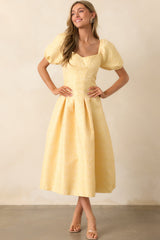 A timeless maxi dress in yellow floral jacquard, featuring delicate details like puff sleeves and a fitted bodice.