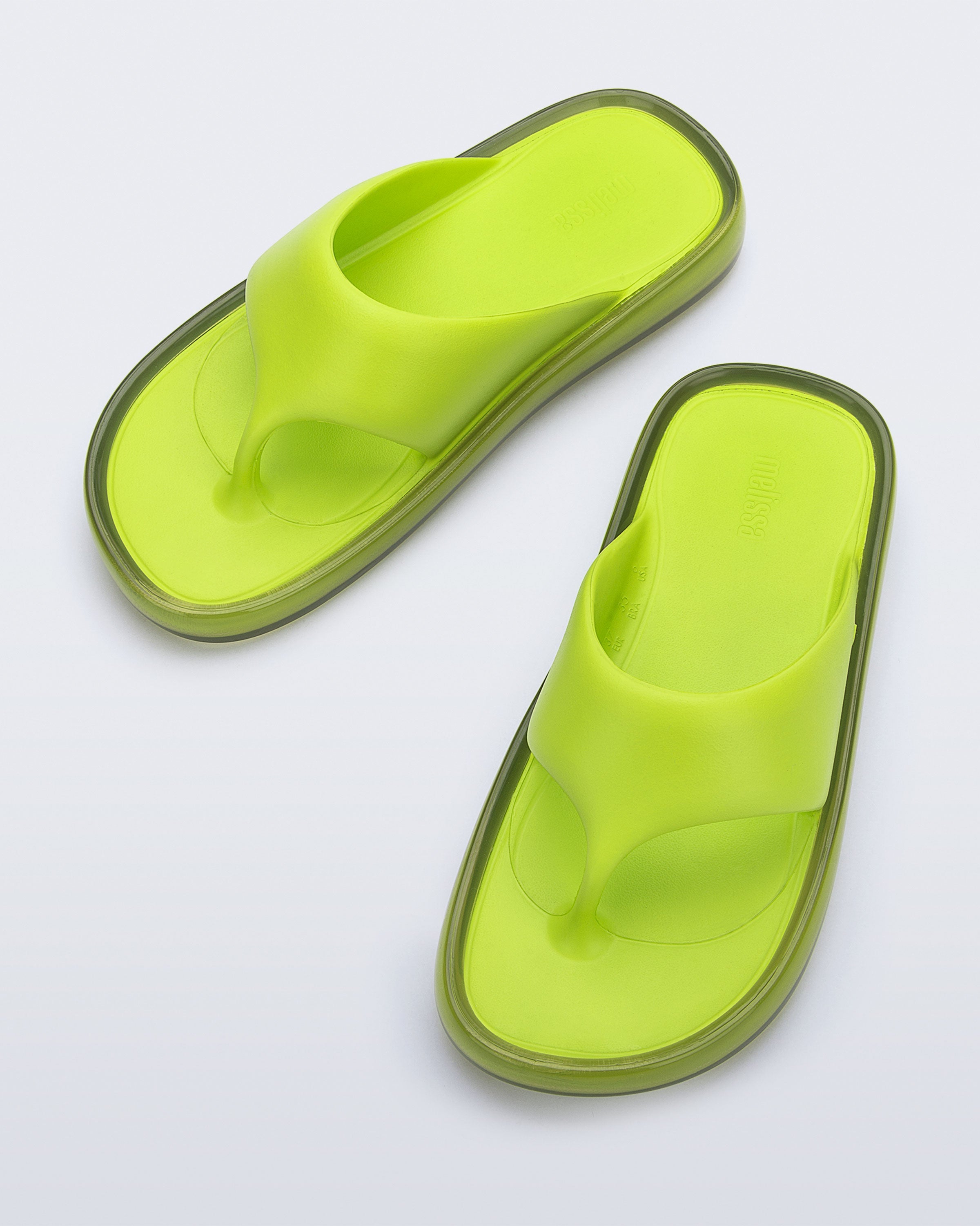 Top view of a pair of green Float flip flops