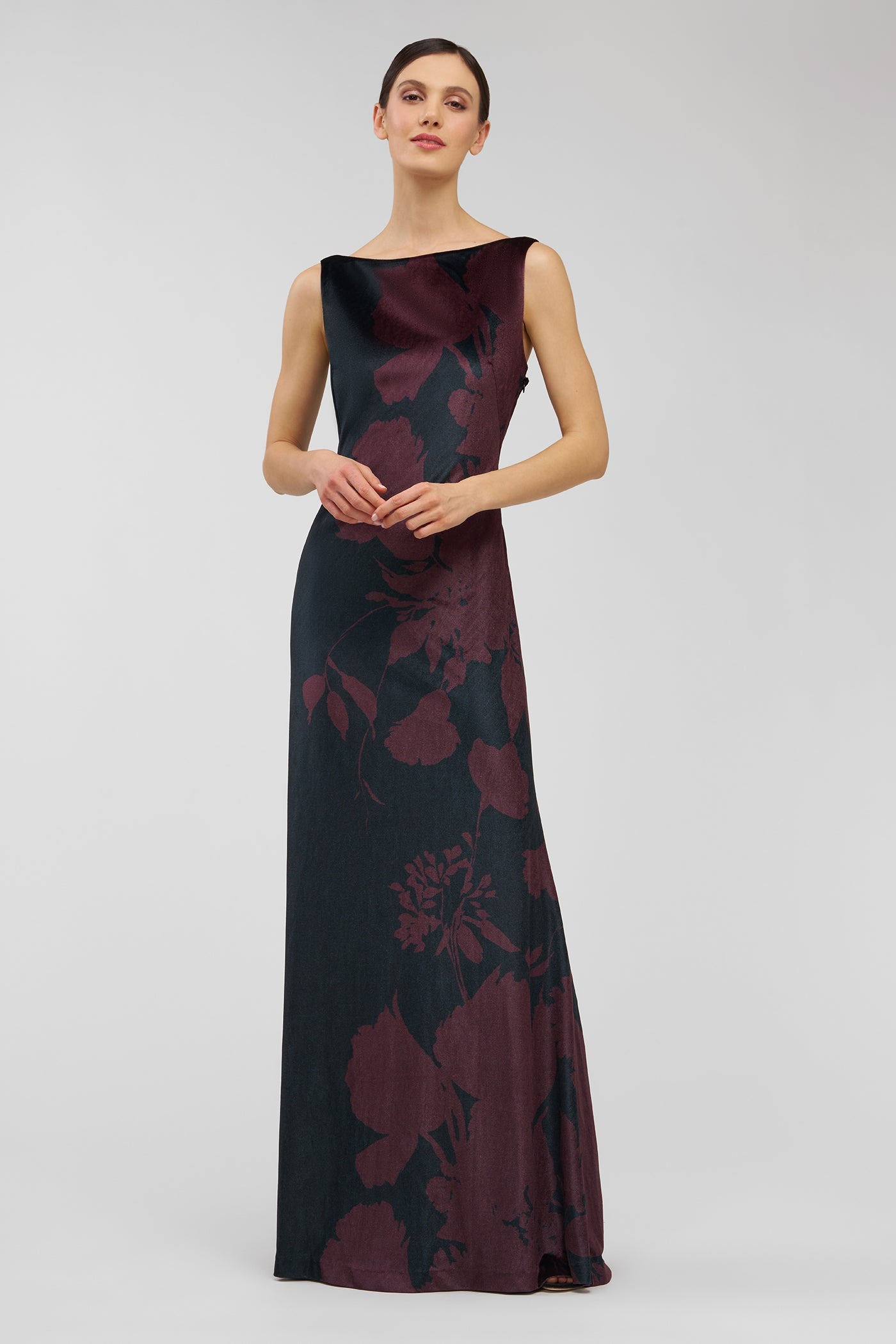 Woman wearing a dark floral patterned dress on a light gray background