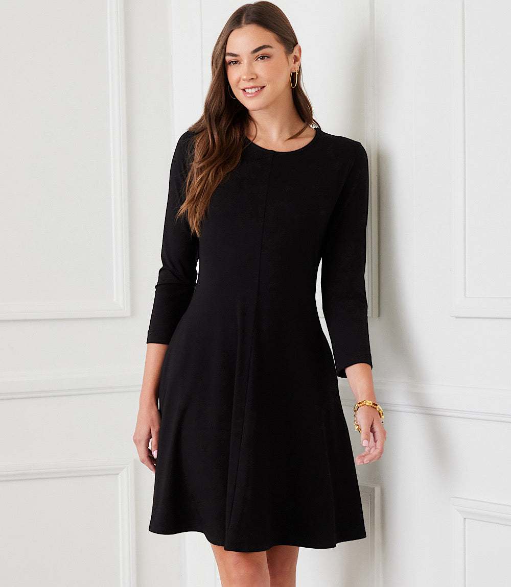 Woman wearing a 3/4 sleeve fit and flare dress in heavy rayon spandex jersey with scoop neck and side pockets