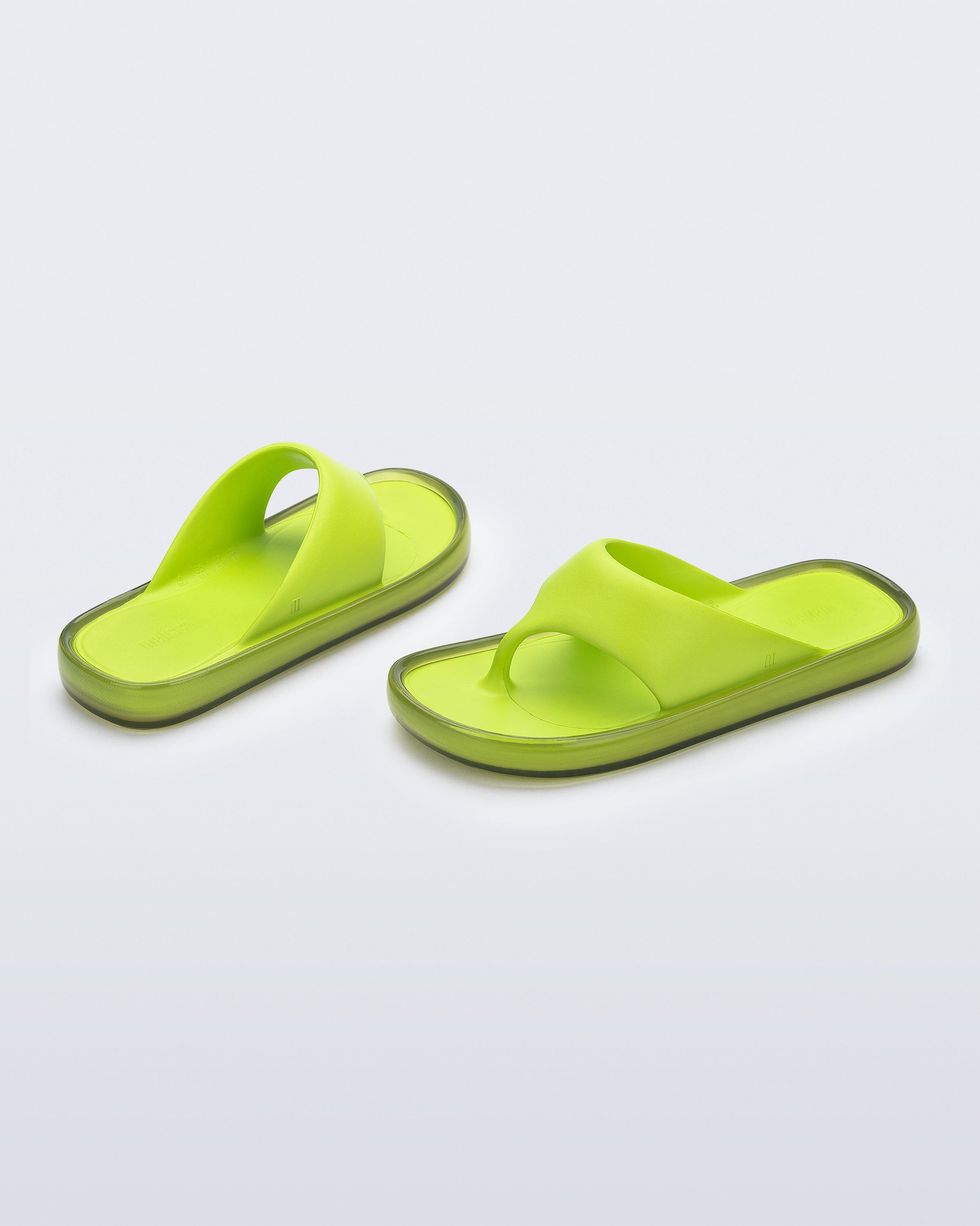 Angled view of a pair of green Float flip flops
