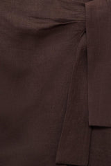 Bruine rok van MANGO, met een subtiele textuur en een decoratieve knoopdetail.
