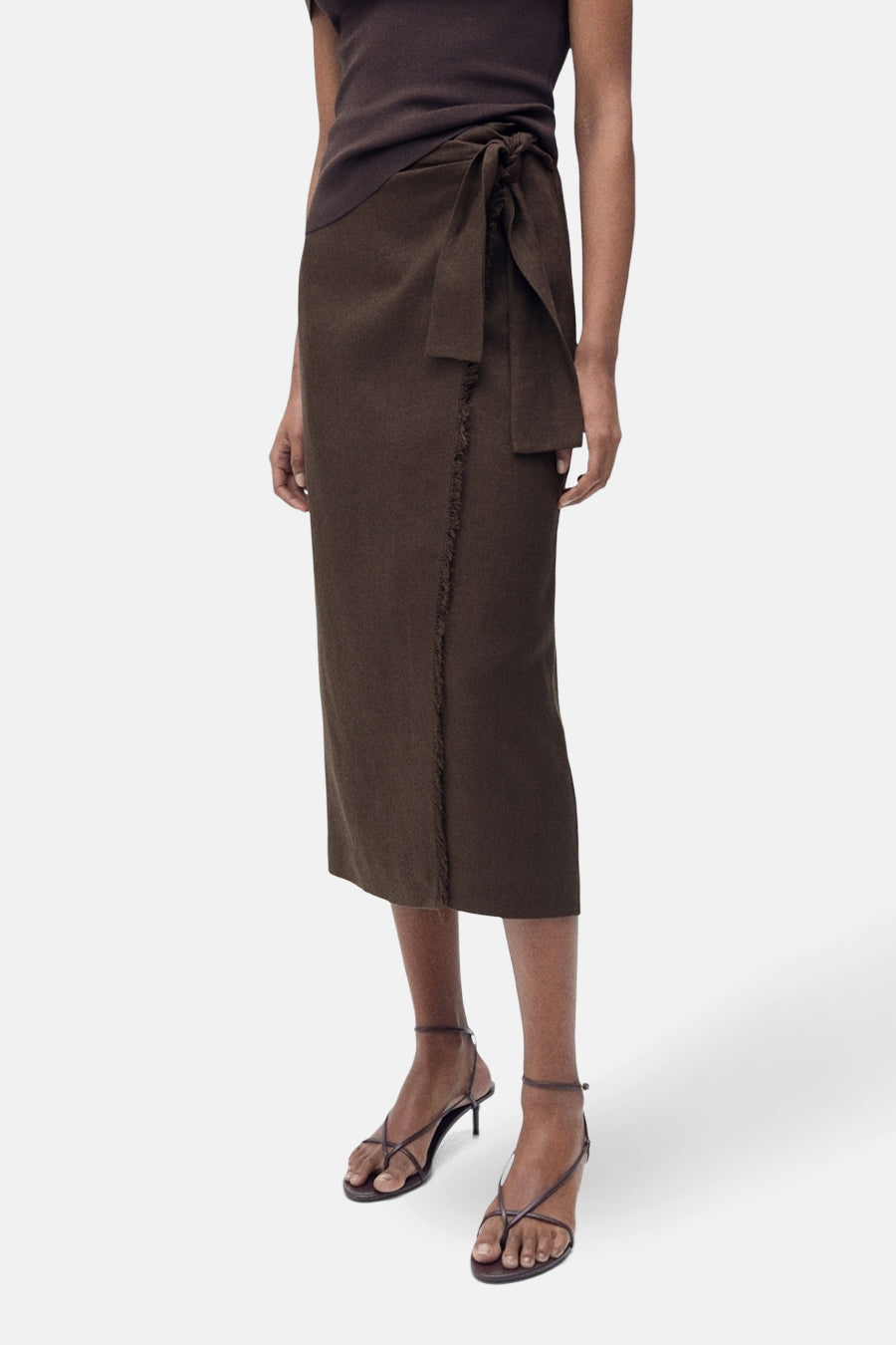 Bruine rok van MANGO, met wikkeldetail en gerafelde rand, gecombineerd met bruine top en strappy hakken.
