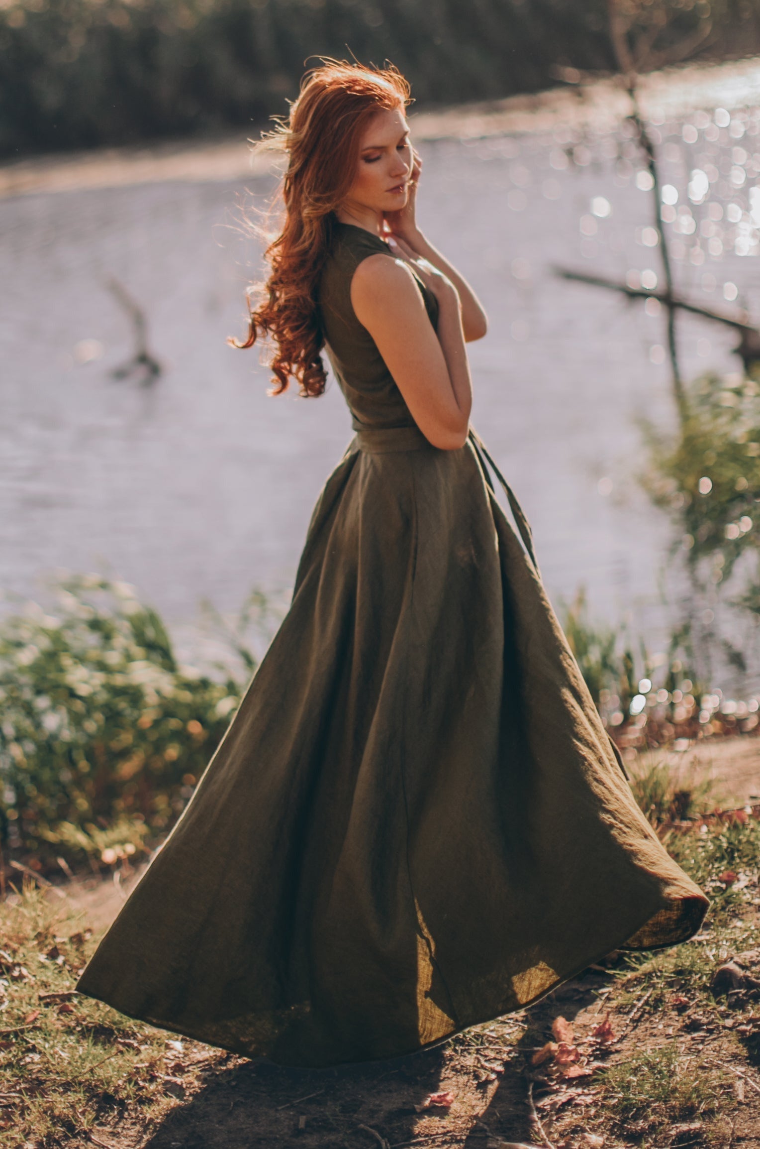 Woman wearing sleeveless linen maxi dress outdoors near water