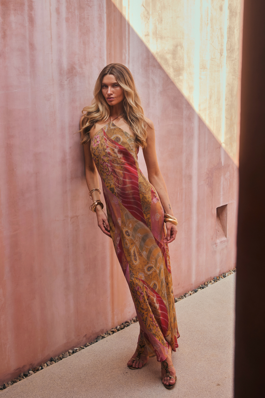 Model wearing the 12th Tribe Isabella Patchwork Maxi Dress, a halter tie-back maxi dress in a sheer, lightweight bias-cut chiffon with patchwork detailing and back neckline gripper tape, perfect for summer soirées, festival-ready looks, and effortless vacation styling